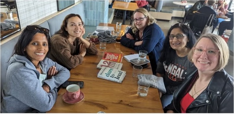 Women in Agile Columbus members gathered around a cafe table with books